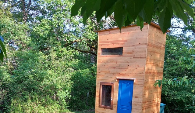 Wooden hut accessible by a path at the edge of the woods