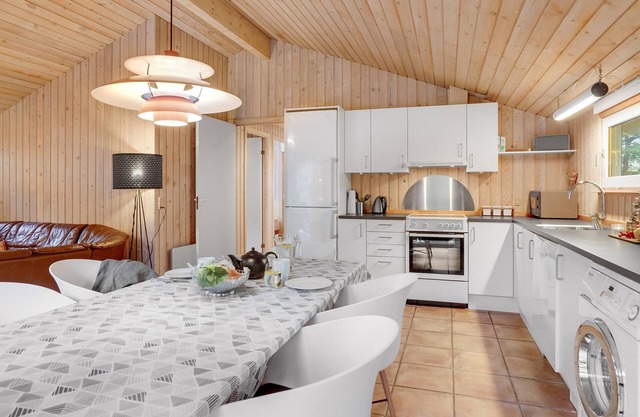 On a hilly natural plot surrounded by trees, lies this beautiful wooden vacation home.