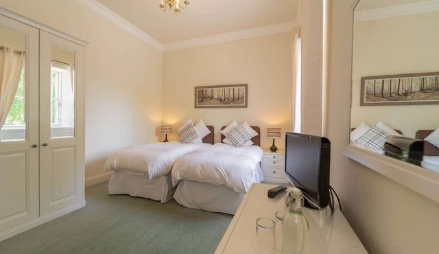 This spacious twin room, located on the first floor, boasts relaxing neutral decor,